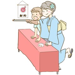 日本の祭りの射的屋台で、的を狙って構える浴衣姿の女の子と男の子