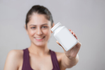 Close-up Of Female Hand Holding Plastic Pill Bottle Containing Vitamins