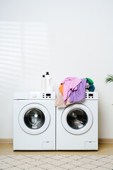White Washing Machines With Colorful Clothes in a Laundry Room
