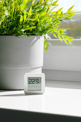 White Digital Thermometer Displaying Room Temperature and Humidity