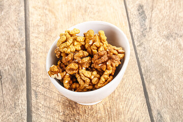 Cracked unshelled walnut in the bowl