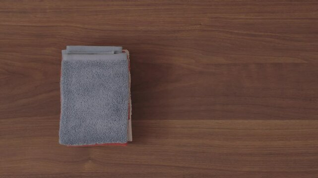 A woman putting towels on the floor or table. 床またはテーブルの上にタオルを置く女性