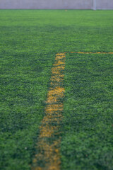 White and Yellow lines on a sports field. With artificial grass, this will utilize for many kinds of sports in school; football, rugby, softball.