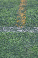 White and Yellow lines on a sports field. With artificial grass, this will utilize for many kinds of sports in school; football, rugby, softball.
