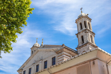 Historic Church with Twin Bell Towers and Crosses Against a Blue Sky