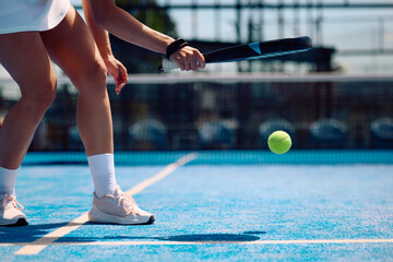 Unrecognizable female athlete playing paddle ball tennis.