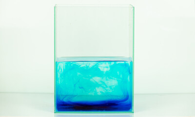 A clear glass container with blue and white liquid in it