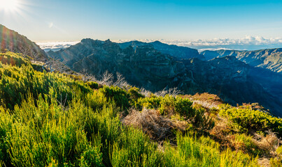 Fototapeta premium Hiking on the highest peak of Madeira Pico Ruivo next to the cottage Abrigo do Pico Ruivo. Views of the surrounding mountains lanscape during sunny day