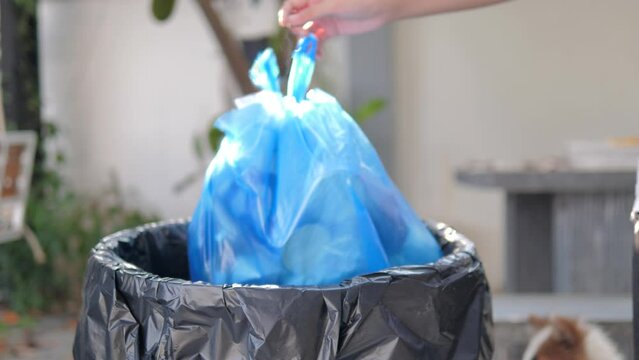 Slow motion hand of people sort waste plastic water bottles and throw them into the trash can to separate waste for recycle 