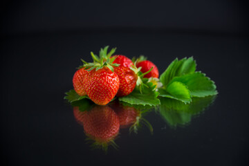 red ripe strawberry spring on a black background