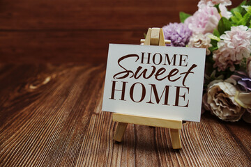 Naklejka premium Home Sweet Home text on paper card on wooden background