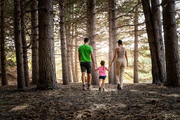 Obraz premium Family Walking in Forest - Outdoor Adventure and Quality Time - back view