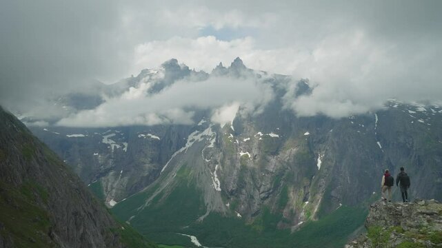 Two hikers on the Litlefjellet hike in Norway with a breathtaking view of Trollveggen Trollwall