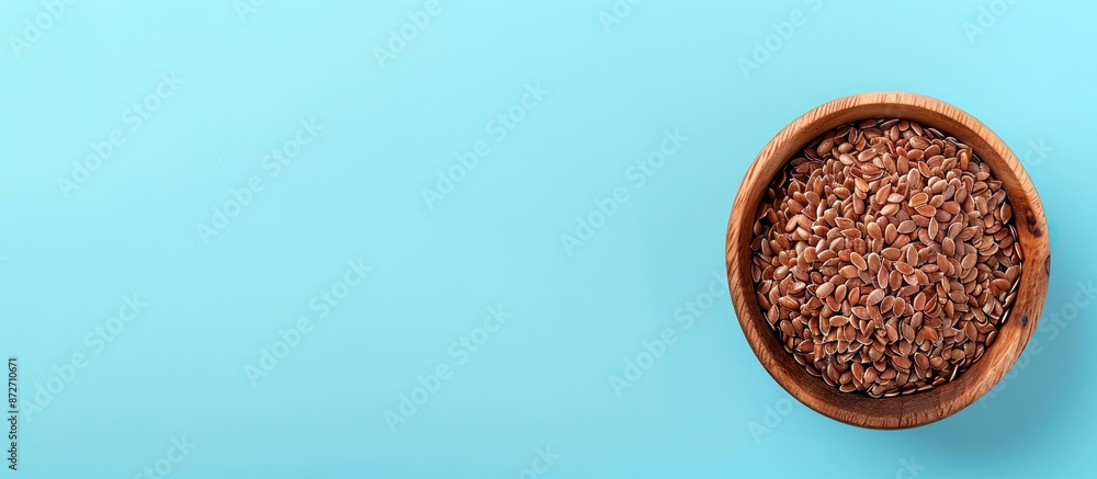 Poster brown flax seeds in wooden bowl isolated on pastel background. with copy space image. place for addi