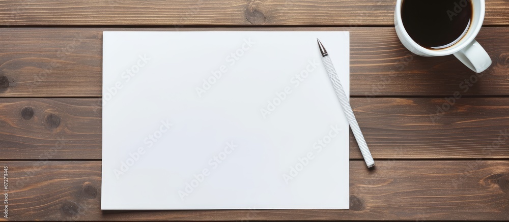 Aufkleber Wooden desk in an office setting featuring a blank notepad, pen, and coffee cup on it. Top-down flat lay view with available space for adding an image. with copy space image