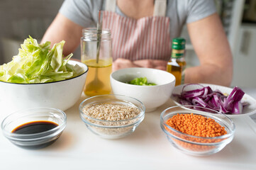 Ingredients for making a healthy vegan dish with brown rice, lentiles, cabbage and vegetables on a cutting board