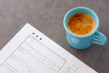 コーヒーを飲みながら、履歴書を書く
