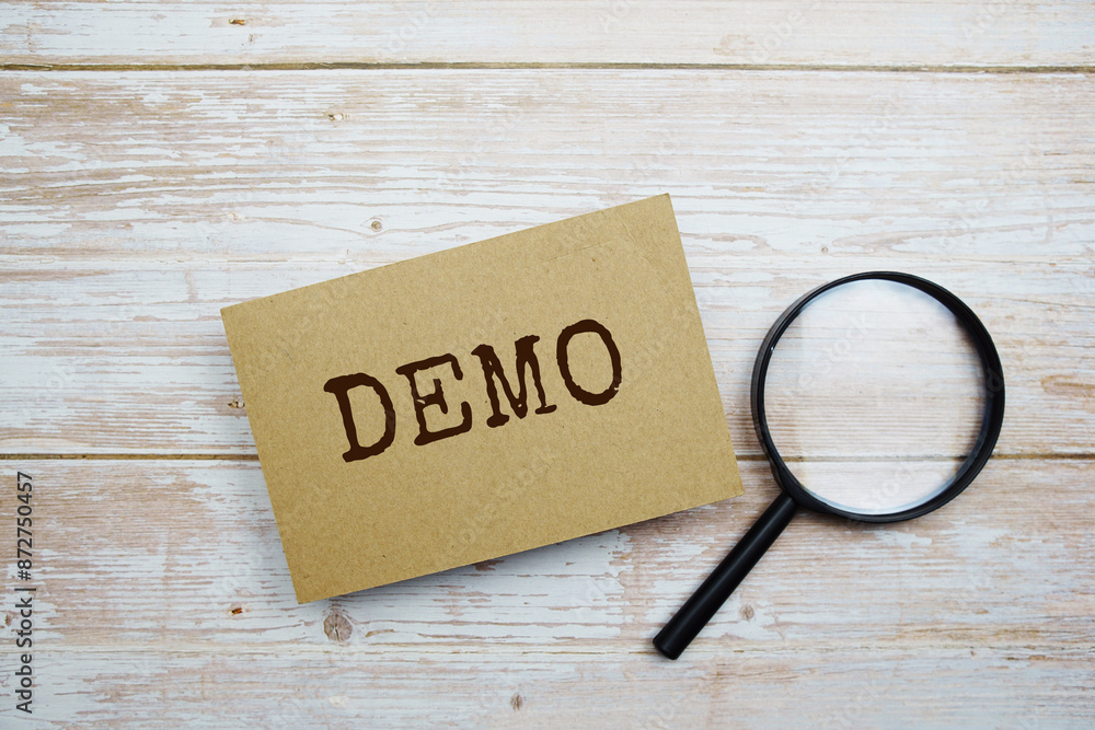 Poster demo text message and magnifying glass with space copy on wooden background
