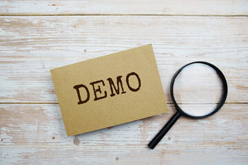 Demo text message and magnifying glass with space copy on wooden background