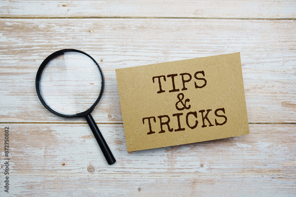 Poster tips & tricks text message and magnifying glass with space copy on wooden background