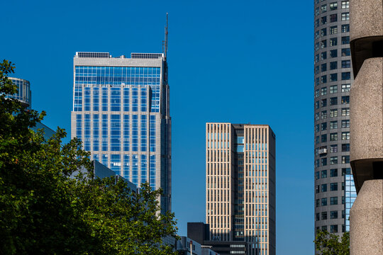 Three towering skyscrapers rise against a flawless blue sky, representing the pinnacle of modern architectural achievement and the dynamic nature of urban development in Rotterdam