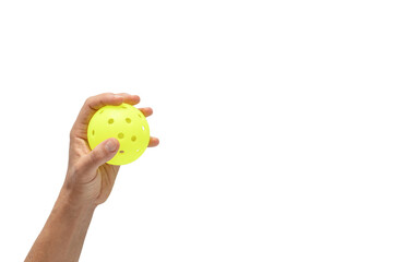 Hand holding a yellow pickleball