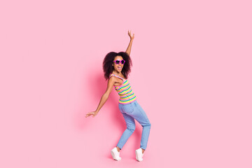 Full length photo of optimistic girl wear colorful top in sunglass dancing on tiptoes on summer party isolated on pink color background