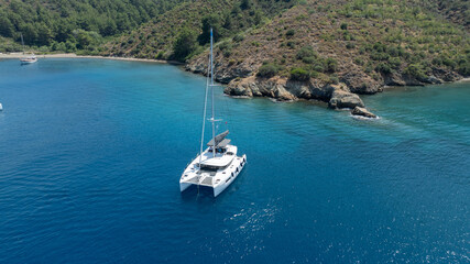 Aerial drone photo of beautiful catamaran sailing yacht anchored in tropical exotic turquoise sea exotic bay