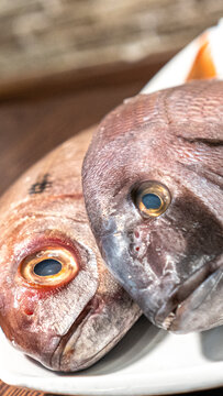 peces reci&eacute;n pescados sobre un plato en mesa de madera