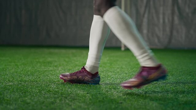 Black soccer player exercising penalty in training hall, scoring goal, back view