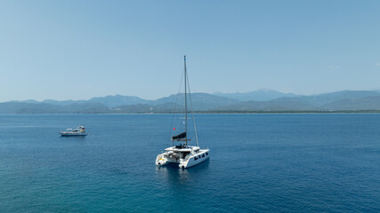 Aerial drone photo of beautiful catamaran sailing yacht anchored in tropical exotic turquoise sea exotic bay