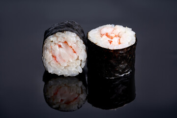 Maki roll with shrimp on a dark background with reflection