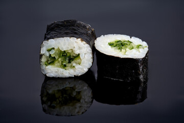 Maki roll with cucumber on a dark background with reflection