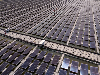 Professional workers clean and inspect solar panels on a floating buoy. Power plant with water..
