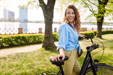 Happy woman riding bicycle bike in the park outdoors. Active urban healthy lifestyle concept