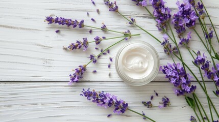 Cosmetic cream with lavender flowers on white wood background