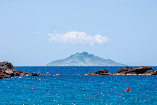 The Island of Montecristo, with the caracteristic withe cloud, in the Tyrrhenian Sea part of the Tuscan Archipelago, Italy