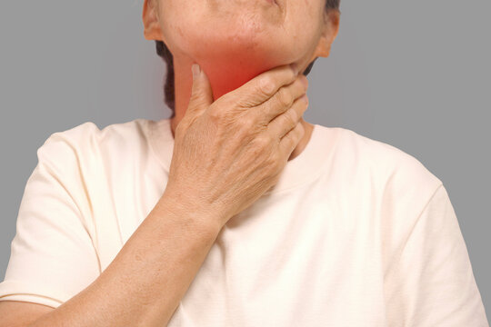 Elderly woman touching her neck with sore throat