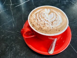 cup of cappuccino coffee on black table
