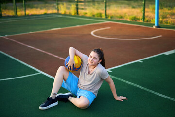 Obraz premium Lifestyle portrait of Cheerful caucasian little girl ten years old holding game ball