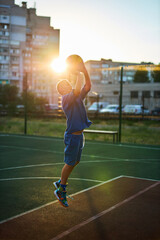 Obraz premium caucasian little basketball player jumps to throw the ball into the basket hoop