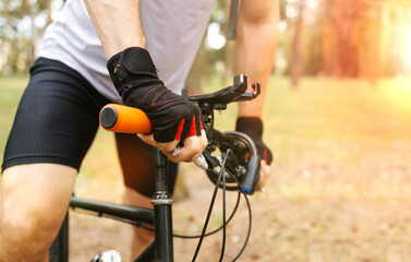 low angle view of cyclist riding mountain bike on sandy trail at sunset. An artistic close up on a mountain biker's run.