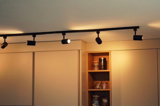 Deckenbeleuchtung einer K&uuml;che mit modernen Schienensystem und Spot-Lampen. 