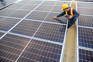 A solar panel installation company employee assembles a photovoltaic system on the roof. © sirisakboakaew
