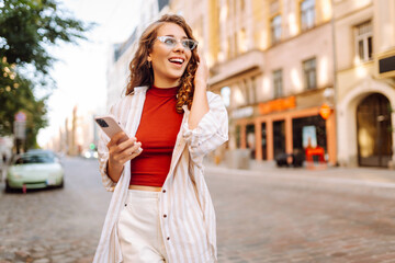 Fototapeta premium Young woman tourist walking around the street, making selfie, communication with friends. Networks, blogging, online shopping concept.