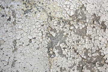 Obsolete backdrop of a cement wall with sun burned while paint, peeling stucco texture, abstract background