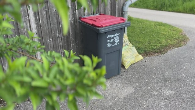 waste paper can and yellow bag near road