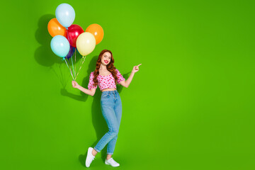 Photo of charming positive woman wear print top holding ballons bunch showing empty space isolated green color background