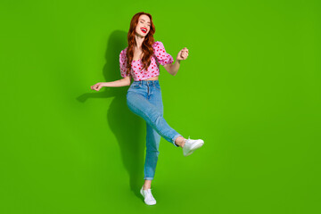 Photo of charming positive woman wear print top dancing empty space isolated green color background