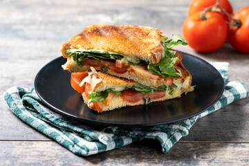 Healthy spinach, tomato and cheese sandwich on wooden table